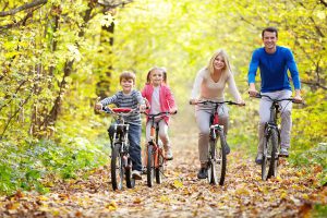 Family on bikes in the park in autumn